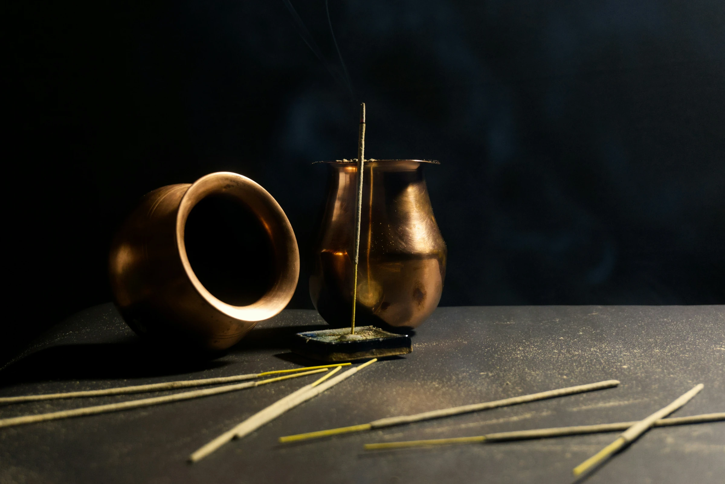 Acupuncture needles beside a lit incense stick