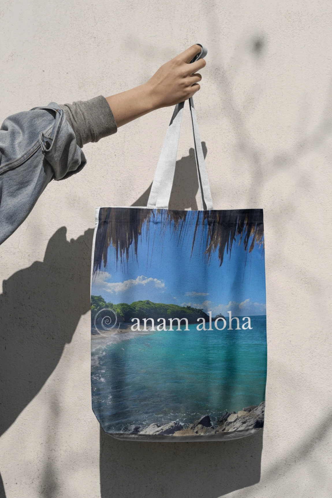 anam aloha branded tote bag printed with the beach coastline photo and logo