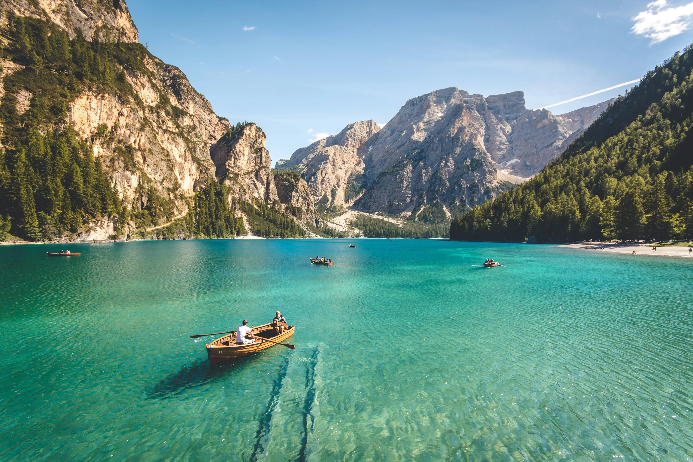 Turquoise mountain lake with wooden rowboats